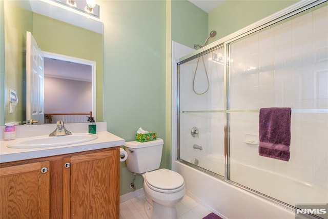 full bathroom featuring vanity, tile patterned flooring, toilet, and bath / shower combo with glass door