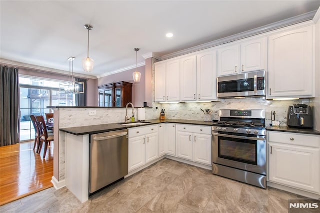 kitchen featuring appliances with stainless steel finishes, a sink, dark countertops, ornamental molding, and backsplash