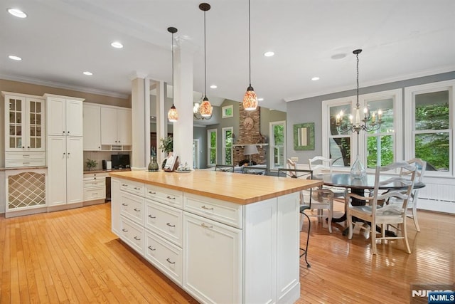 125 Bellevue Ave, Montclair, NJ 07043 - kitchen featuring wood counters, ornamental molding, light wood-style flooring, hanging light fixtures, and white cabinetry