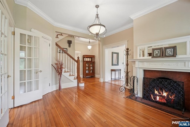 125 Bellevue Ave, Montclair, NJ 07043 - entryway featuring ornamental molding, stairway, light wood-style flooring, a warm lit fireplace, and baseboards