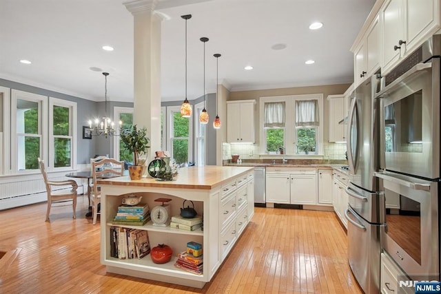 125 Bellevue Ave, Montclair, NJ 07043 - kitchen featuring stainless steel appliances, wood counters, crown molding, white cabinets, and hanging light fixtures