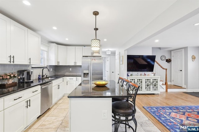 520 Elm St, Roselle Park, NJ 07204 - kitchen with a sink, appliances with stainless steel finishes, a kitchen island, a kitchen breakfast bar, and white cabinetry
