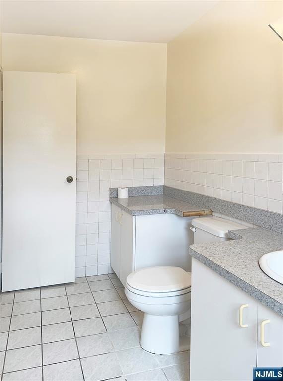 109 N Maple, Park Ridge, NJ 07656 - bathroom with tile walls, tile patterned flooring, toilet, vanity, and a wainscoted wall
