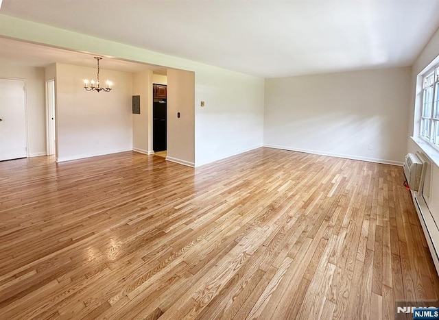 109 N Maple, Park Ridge, NJ 07656 - spare room featuring a chandelier, light wood-style flooring, baseboards, and baseboard heating