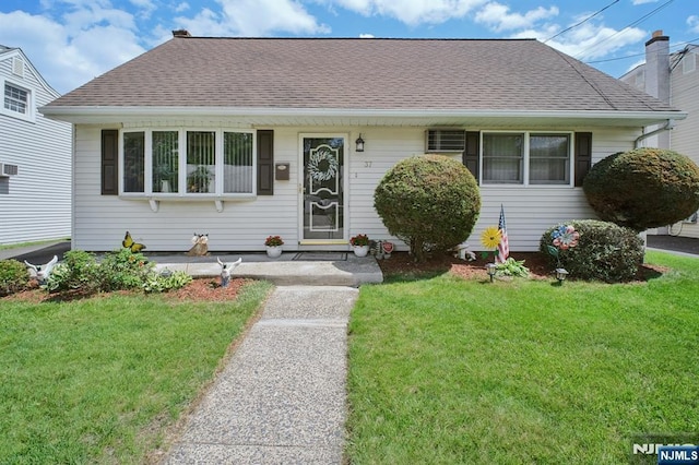 bungalow with a front yard and a shingled roof