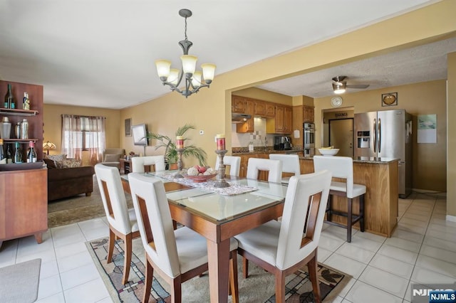 dining room featuring a chandelier, light tile patterned floors, and ceiling fan