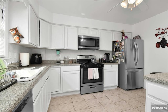 127 Brill St, Newark, NJ 07105 - kitchen with appliances with stainless steel finishes, white cabinetry, a ceiling fan, and decorative backsplash