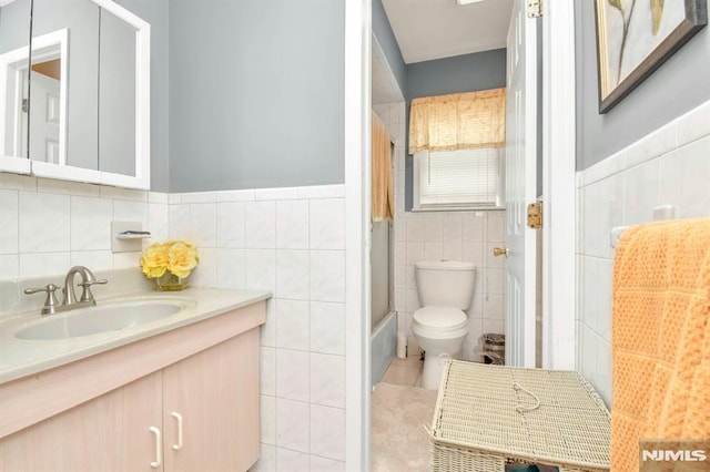 127 Brill St, Newark, NJ 07105 - full bathroom with tile walls, toilet, vanity, tile patterned floors, and wainscoting