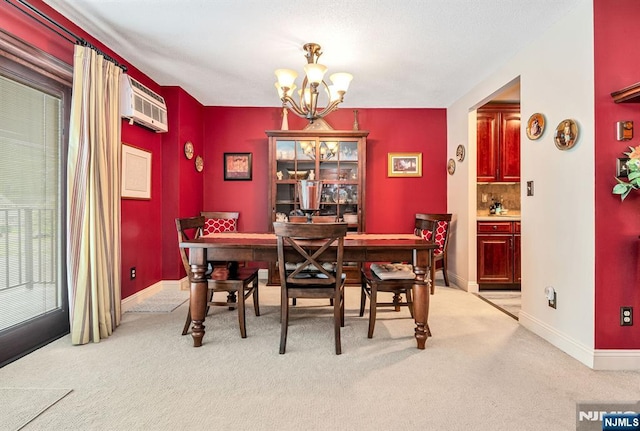 dining area featuring a chandelier, an AC wall unit, light colored carpet, and baseboards