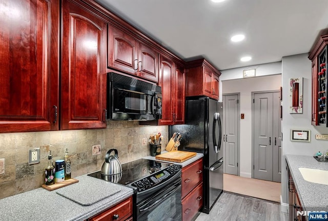 kitchen featuring black appliances, reddish brown cabinets, light wood finished floors, light countertops, and recessed lighting