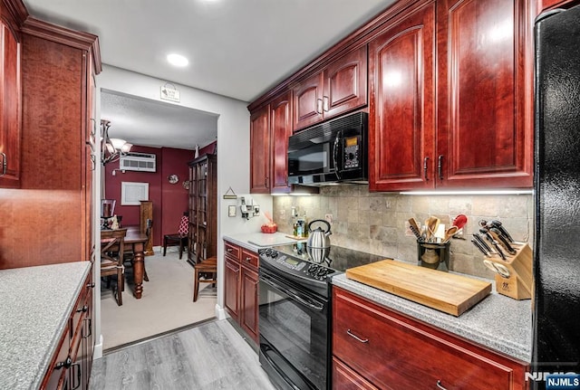 kitchen with black appliances, reddish brown cabinets, light wood finished floors, light countertops, and recessed lighting