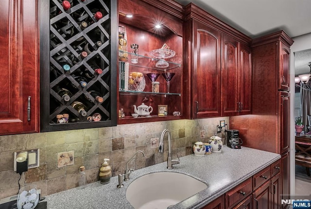 bar area featuring a sink and backsplash