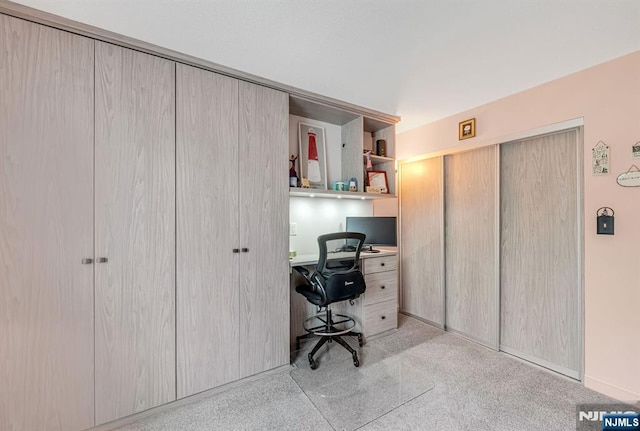 office space featuring built in study area and light carpet
