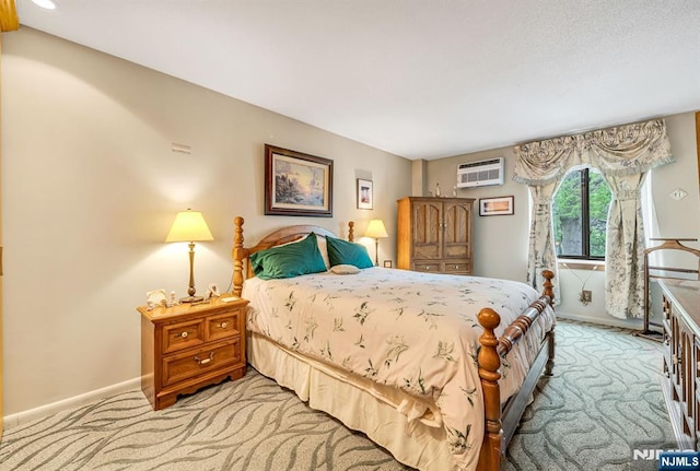 bedroom with light carpet, baseboards, and an AC wall unit