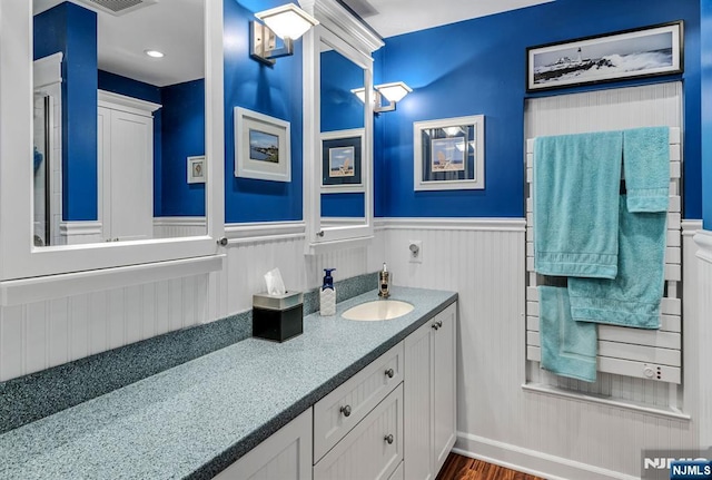 bathroom featuring a wainscoted wall, vanity, and wood finished floors