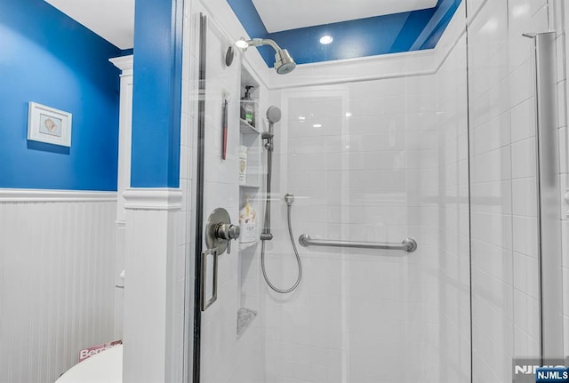 bathroom featuring a stall shower and wainscoting