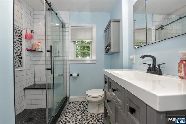 bathroom with a shower stall, toilet, tile patterned floors, and baseboards