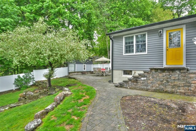 view of yard featuring fence, an outbuilding, and a patio