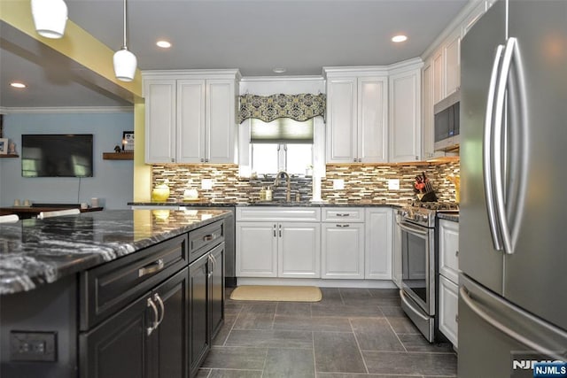 kitchen with stainless steel appliances, a sink, white cabinets, ornamental molding, and decorative backsplash
