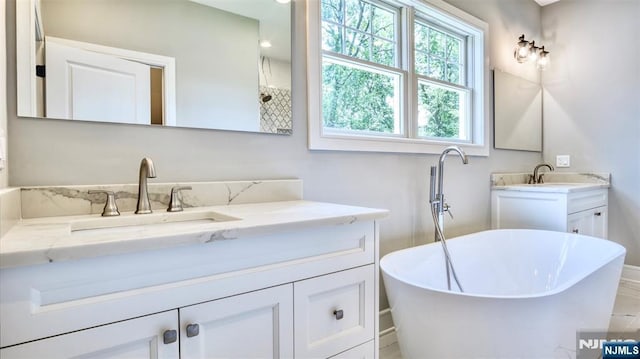 bathroom with vanity and a soaking tub