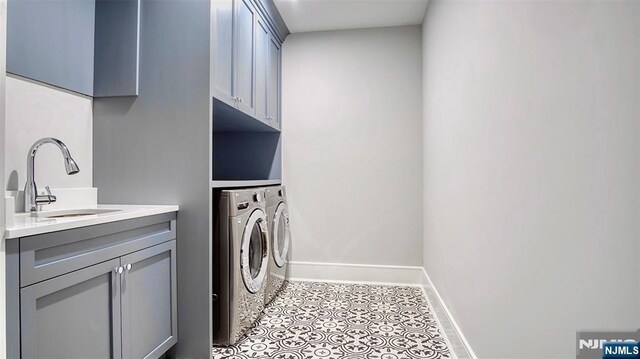 laundry room featuring washer and dryer, cabinet space, baseboards, and light tile patterned flooring