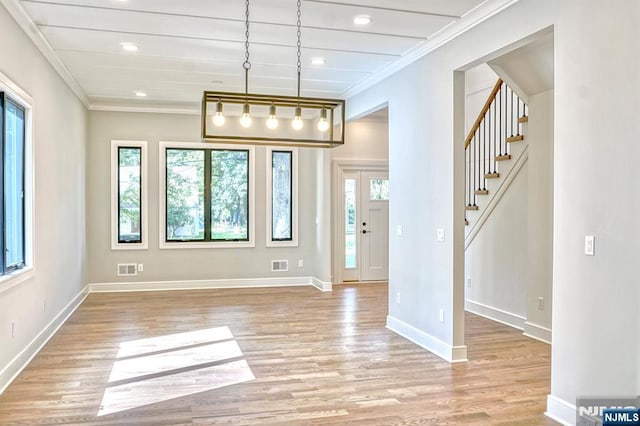 unfurnished dining area featuring ornamental molding, healthy amount of natural light, light wood-style floors, stairs, and recessed lighting