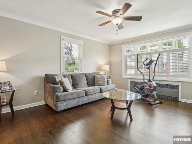 living room featuring radiator heating unit, baseboards, crown molding, wood finished floors, and ceiling fan