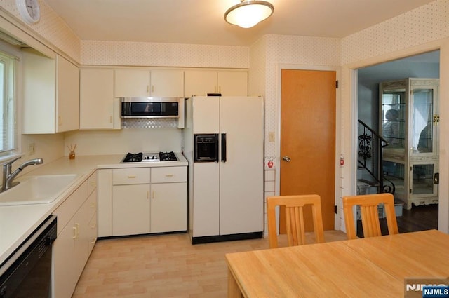 36 Joyce Ln, Wayne, NJ 07470 - kitchen featuring white refrigerator with ice dispenser, stainless steel microwave, a sink, dishwasher, and wallpapered walls