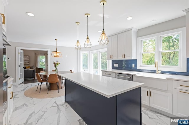 kitchen featuring light marble finish floors, recessed lighting, plenty of natural light, backsplash, and a kitchen island