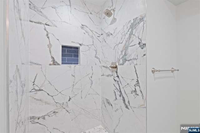 bathroom with a marble finish shower