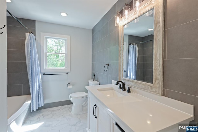 full bathroom featuring tile walls, marble finish floors, toilet, vanity, and shower / bath combo with shower curtain