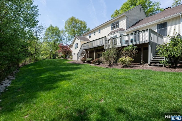 back of house with stairway, a wooden deck, and a lawn
