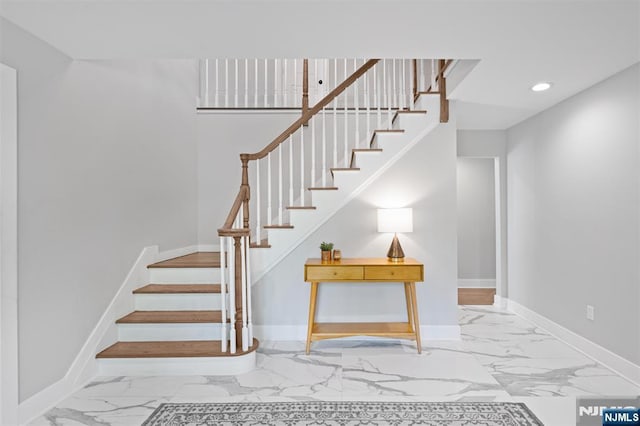 stairway with marble look tile flooring, baseboards, and recessed lighting