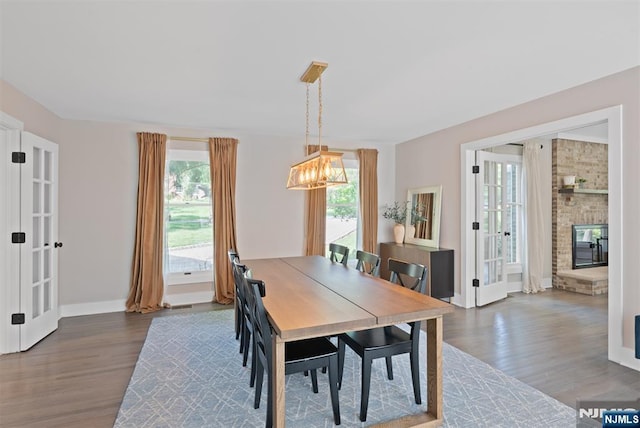 dining room featuring french doors, wood finished floors, a chandelier, and baseboards