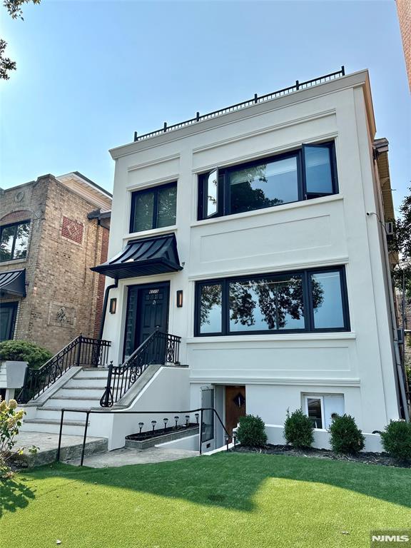 6115 Kennedy Blvd, West New York, NJ 07093 - view of front of property with a front yard and stucco siding