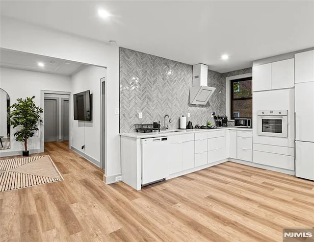 6115 Kennedy Blvd, West New York, NJ 07093 - kitchen featuring white appliances, wall chimney exhaust hood, light countertops, a sink, and decorative backsplash