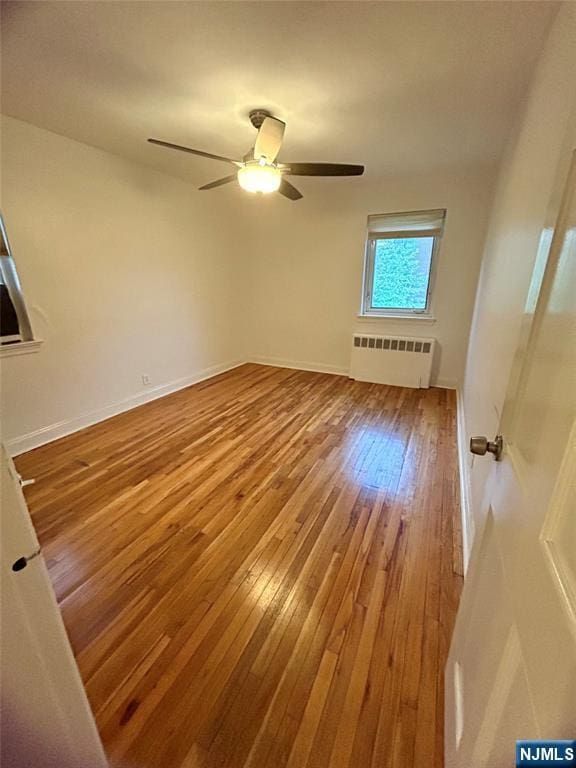 1481 E Terrace Cir Unit 4, Teaneck, NJ 07666 - unfurnished room with radiator, hardwood / wood-style flooring, a ceiling fan, and baseboards