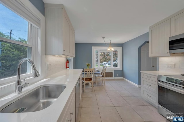 kitchen featuring a sink, appliances with stainless steel finishes, and healthy amount of natural light