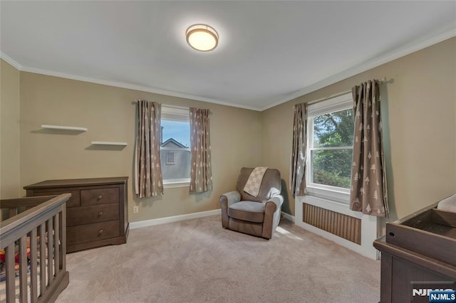 bedroom featuring radiator, ornamental molding, baseboards, light carpet, and a crib