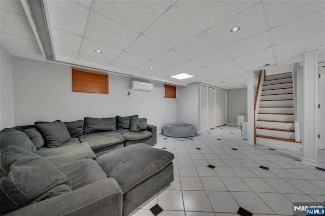 living area with a wall mounted air conditioner, stairs, a drop ceiling, recessed lighting, and light tile patterned floors
