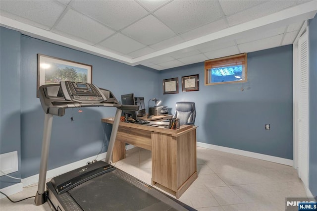 tiled office featuring a paneled ceiling and baseboards