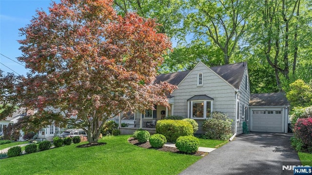 view of front facade with a front lawn, driveway, a garage, and a shingled roof