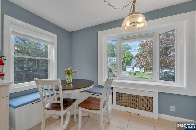 dining area with radiator heating unit and light tile patterned floors