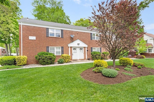 view of front of house featuring a front lawn and brick siding