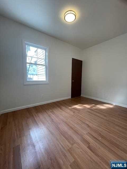 empty room with wood finished floors and baseboards