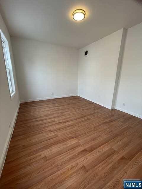 empty room with wood finished floors and baseboards