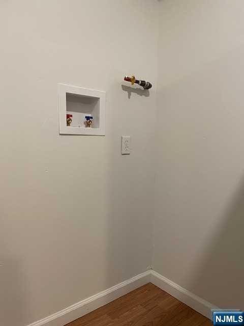 washroom with washer hookup, baseboards, and wood finished floors