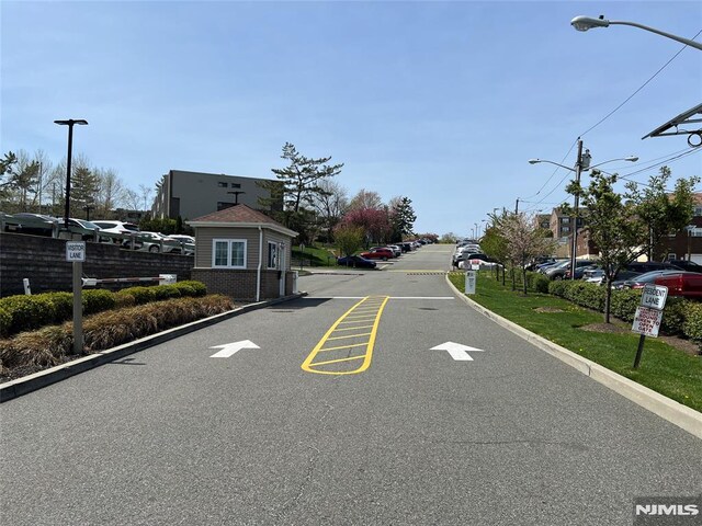 view of asphalt road with street lighting and curbs