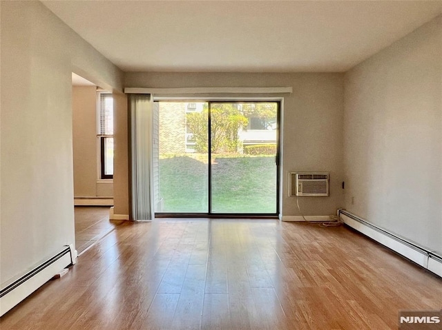 unfurnished room featuring a baseboard heating unit, a wall mounted air conditioner, wood finished floors, and a baseboard radiator