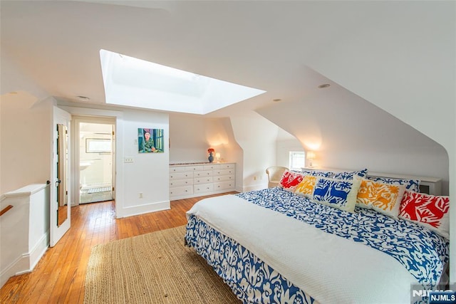 bedroom with hardwood / wood-style floors, baseboards, and a skylight